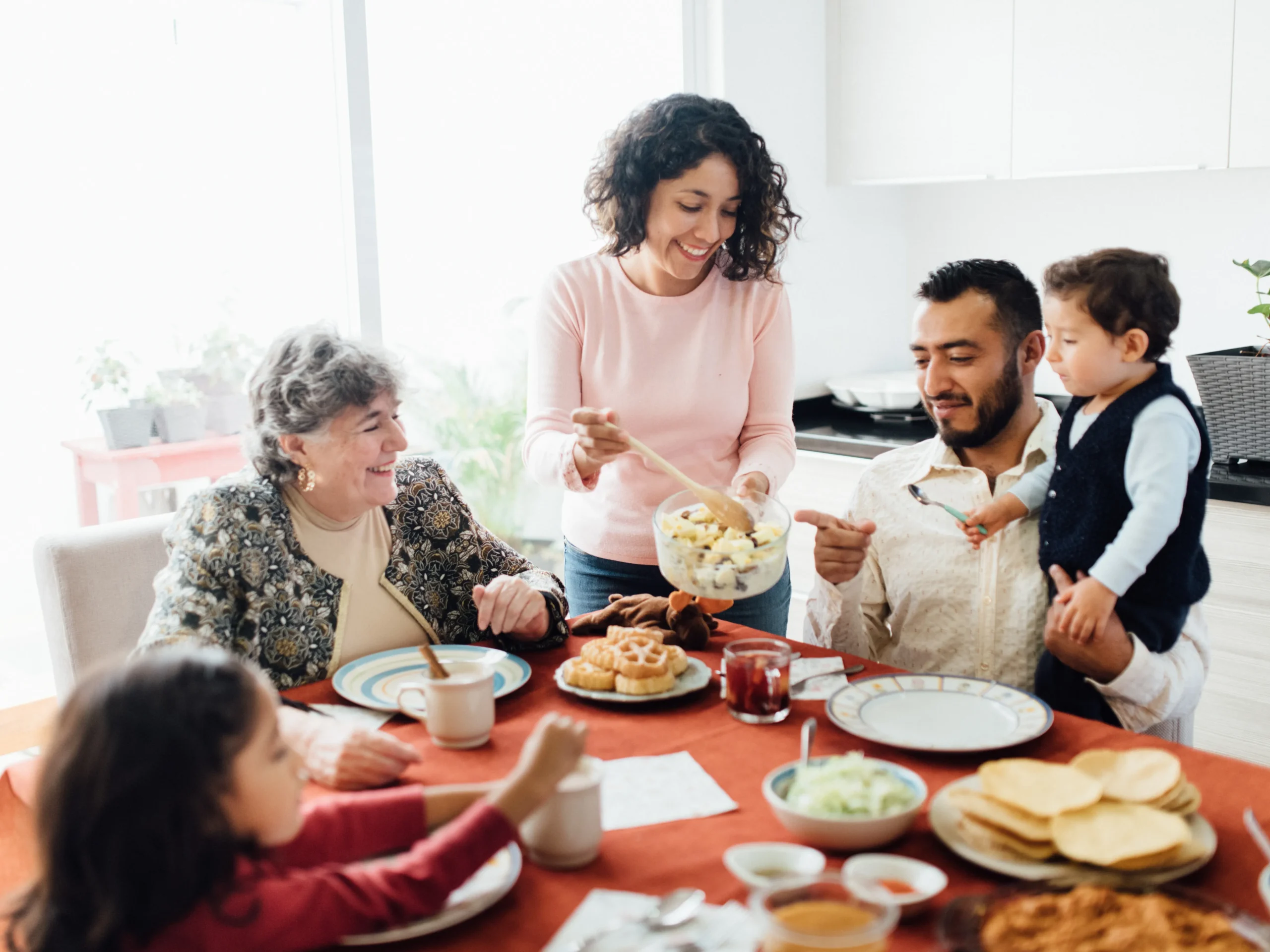 Elderly woman enjoying a meal with her family to motivate healthy eating habits for seniors