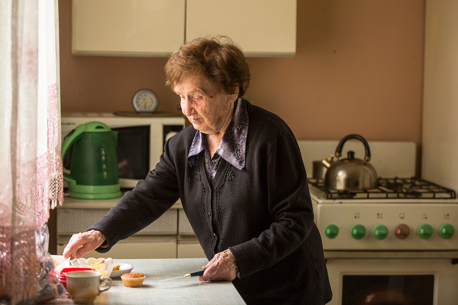 Aging In Place - senior woman in the kitchen preparing breakfast