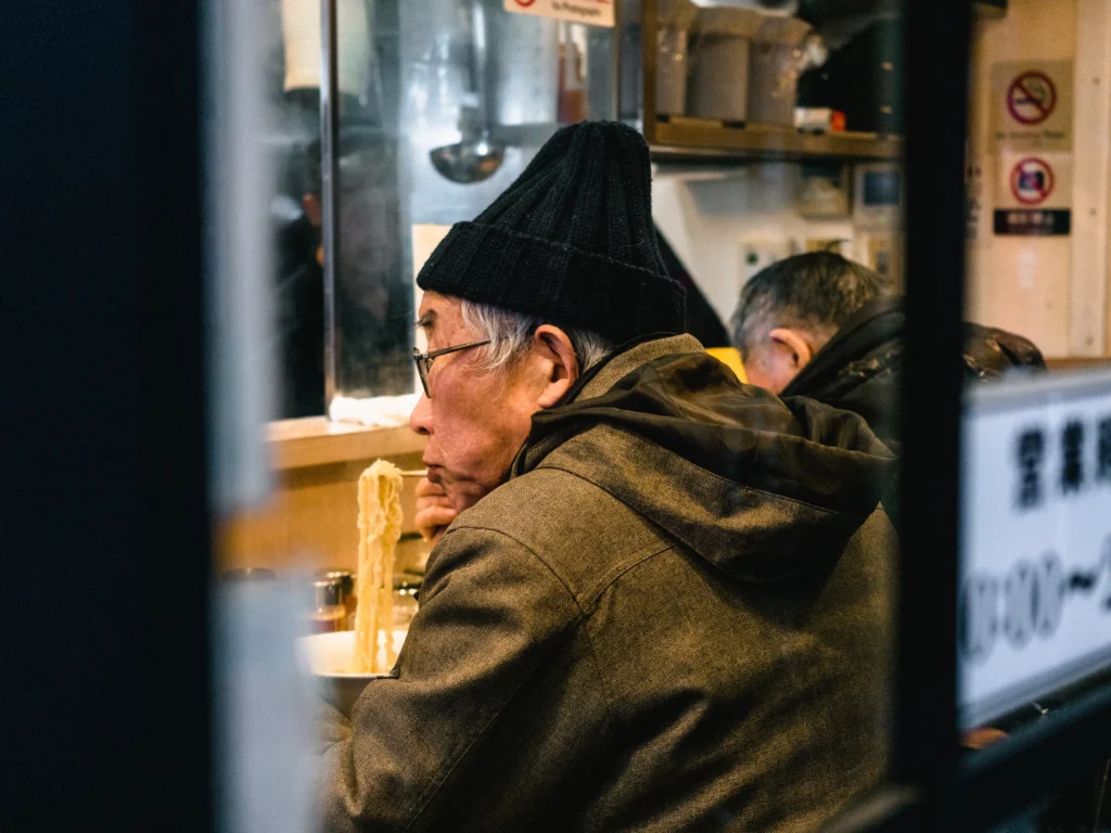 Elderly man eating warm noodles